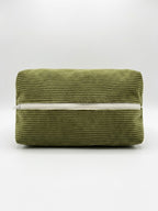 An olive green corduroy zippered pouch with a white zipper, photographed against a neutral light gray background.