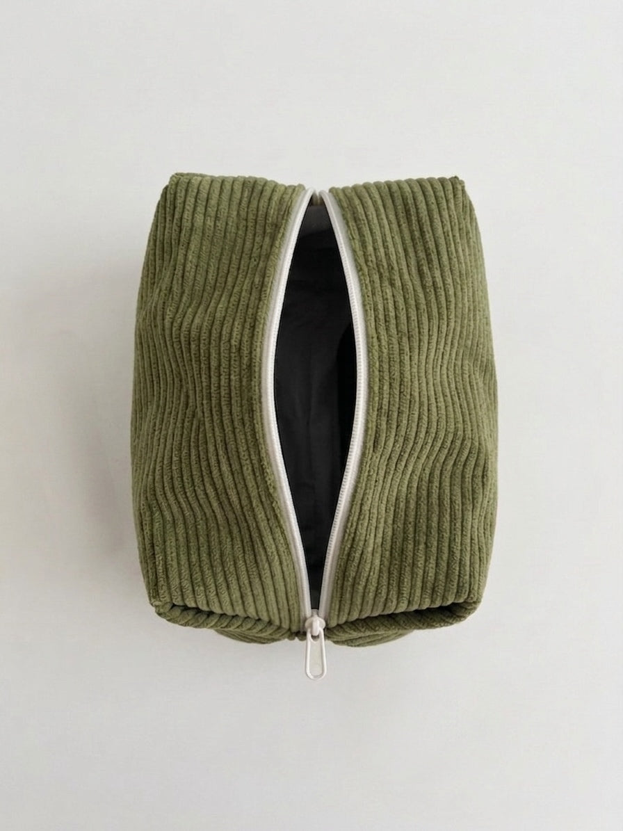An olive green corduroy zippered pouch with a white zipper trim, shown open against a plain light gray background.